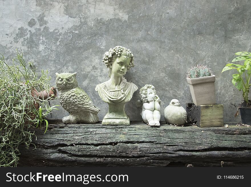 Statue and tree for decoration on cement wall. Vertical garden on timber.