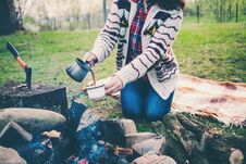 A Girl Is Drinking Coffee By The Fire. Stock Image