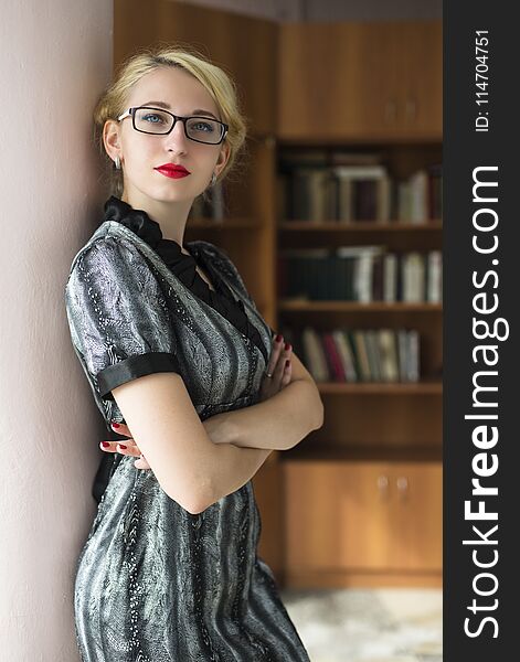 Blond girl in the library on the background of books. Blond girl in the library on the background of books