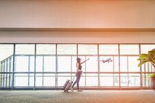 Traveler Women Plan And Backpack See The Airplane At The Airport Glass Window, Girl Tourist Hold Bag And Waiting Near Luggage In H Royalty Free Stock Image