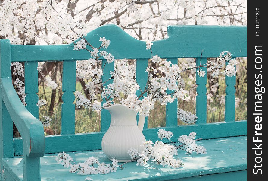 White spring flowers on bench in garden