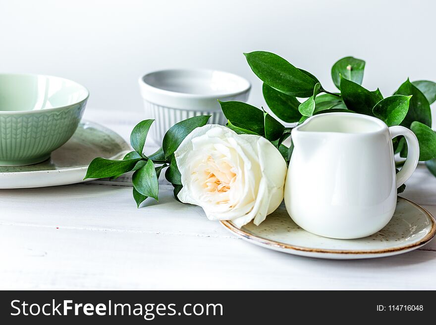 Ceramic tableware with flowers on white background