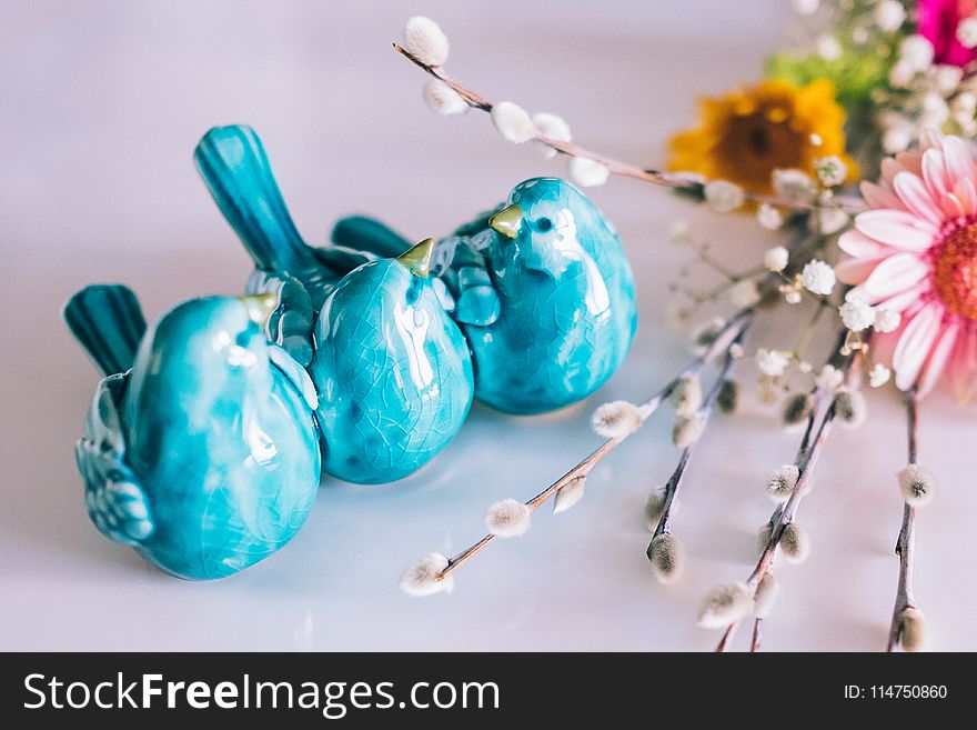 Three Blue Ceramic Bird Decors Beside Pink Flower