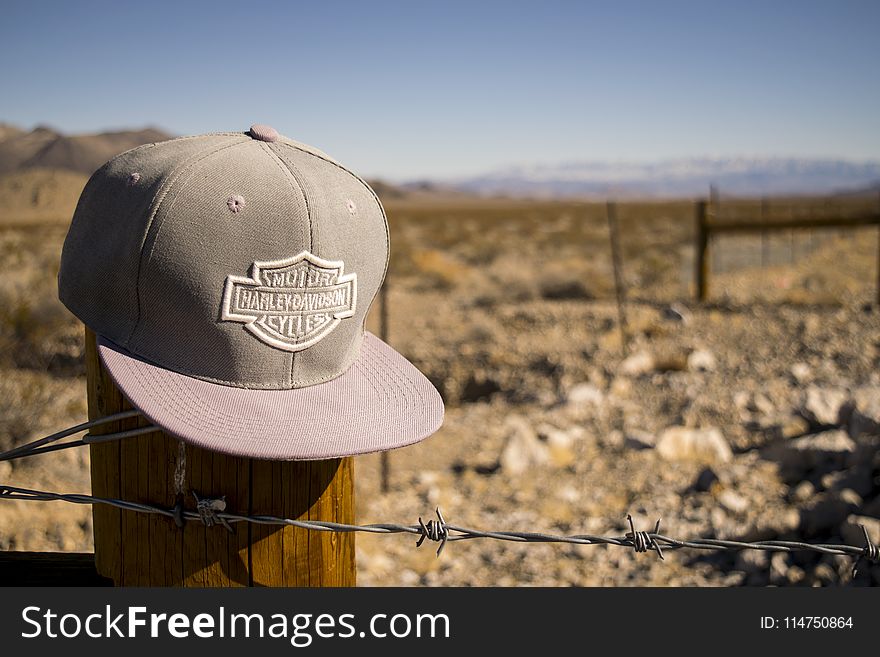 Gray Harley-davidson Motorcycles Flat-brimmed Cap Hanged on Brown Wooden Fence With Gray Barb Wires