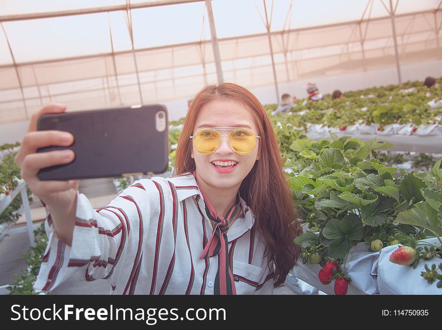 Woman Taking Photo in Front of Platns