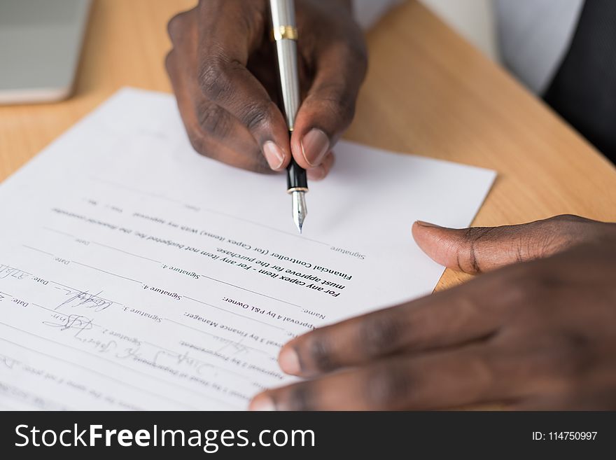 Close-up Photography of Person Writing on White Paper