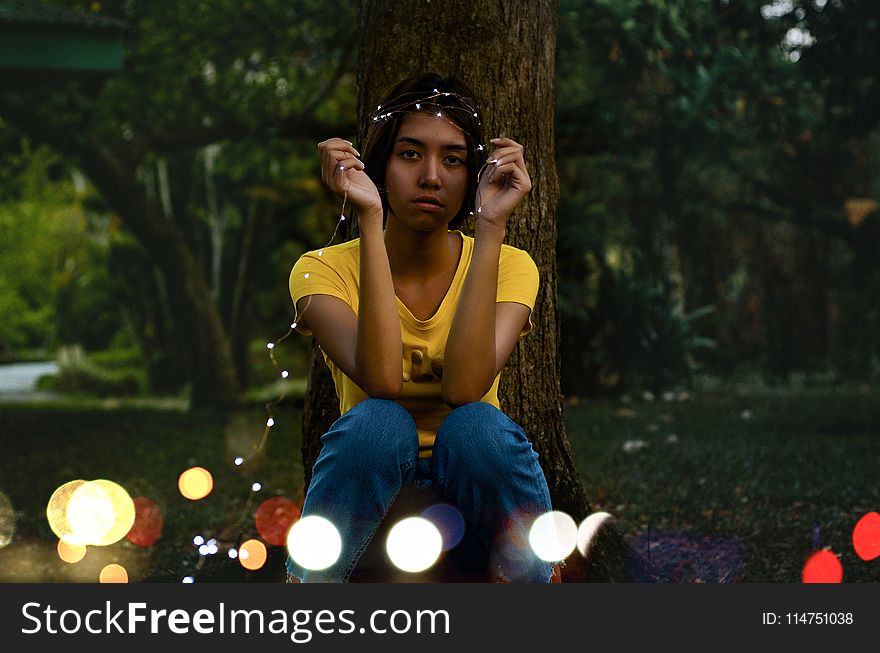 Girl in Yellow Top Sitting Beside Tree