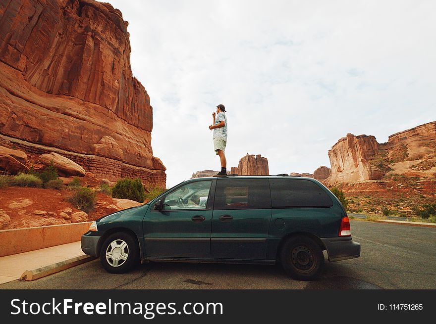 Man Standing On Green Mini Van