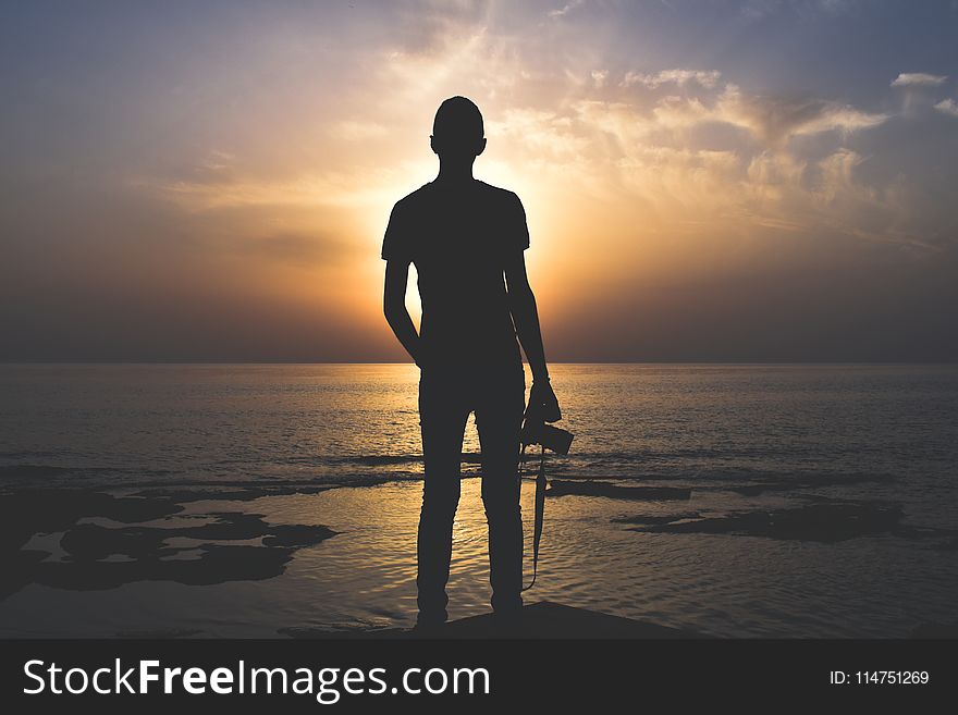 Silhouette Photo of Person Holding Camera