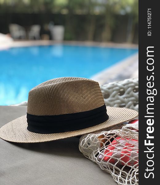 Beige And Black Hat Near Swimming Pool