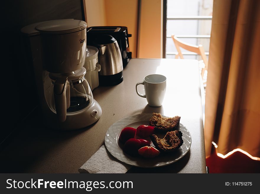 White Ceramic Mug Beside Ceramic Plate On Table