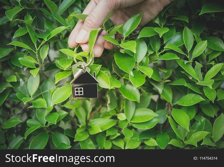 Woman holding home key, environment preservation concept. Woman holding home key, environment preservation concept