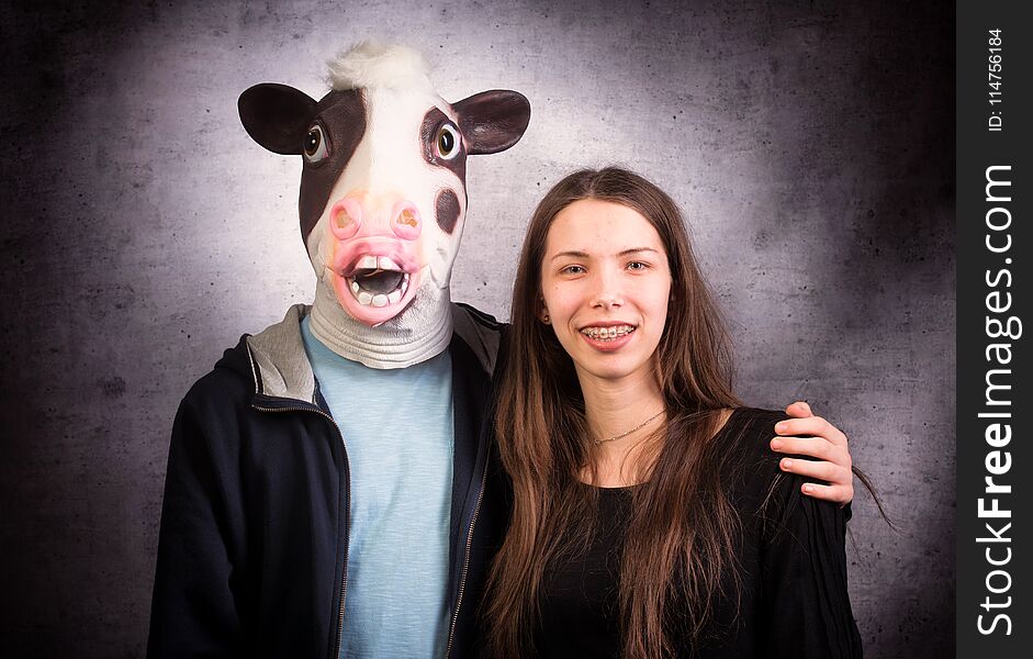 Girl and boy with horse head. Strange couple concept. Studio shot on grey background.