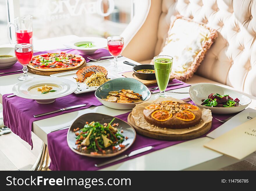 Table In Restaurant With Vegetarian Dishes - Pizza, Salads, Pie And Fresh Natural Drinks.