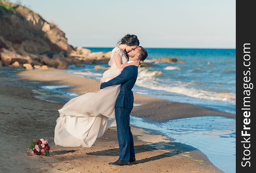 Wedding couple. Beautiful bride and groom. Just merried. Close up. Happy bride and groom on their wedding hugging. Groom and Bride on the beach near the sea. wedding dress. Wedding couple. Beautiful bride and groom. Just merried. Close up. Happy bride and groom on their wedding hugging. Groom and Bride on the beach near the sea. wedding dress.