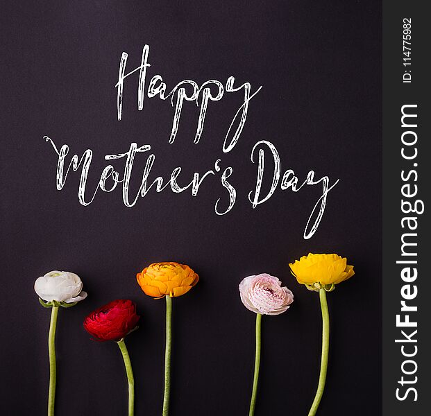 Happy mothers day sign and colored flowers composition. Studio shot on black background. Flat lay. Happy mothers day sign and colored flowers composition. Studio shot on black background. Flat lay.