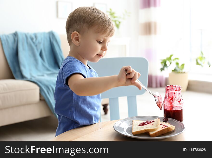 Little Boy Spreading Jam On Toasts At Table