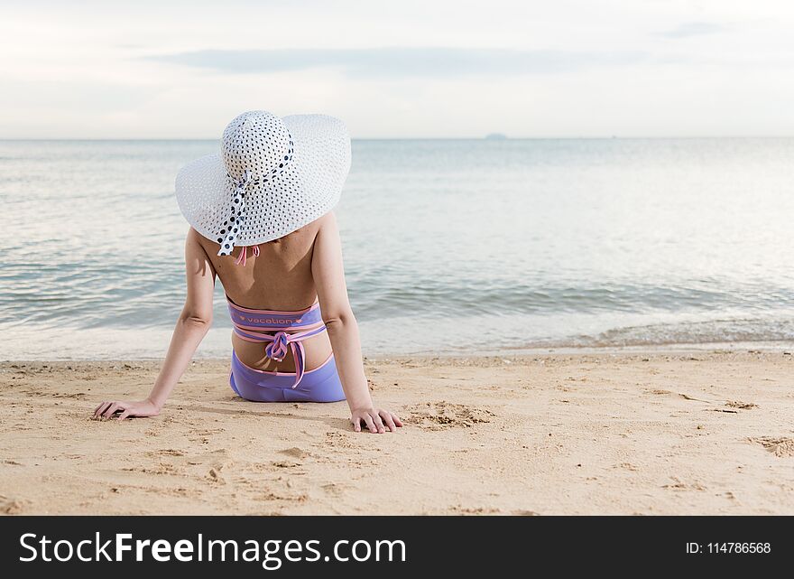 Back woman girl sitting on tropical beach travel relaxation see sea view in vacation summer