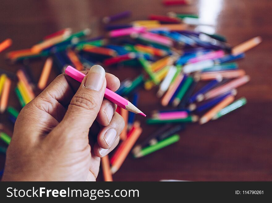 Stack of colored pencils in hands , art design concept