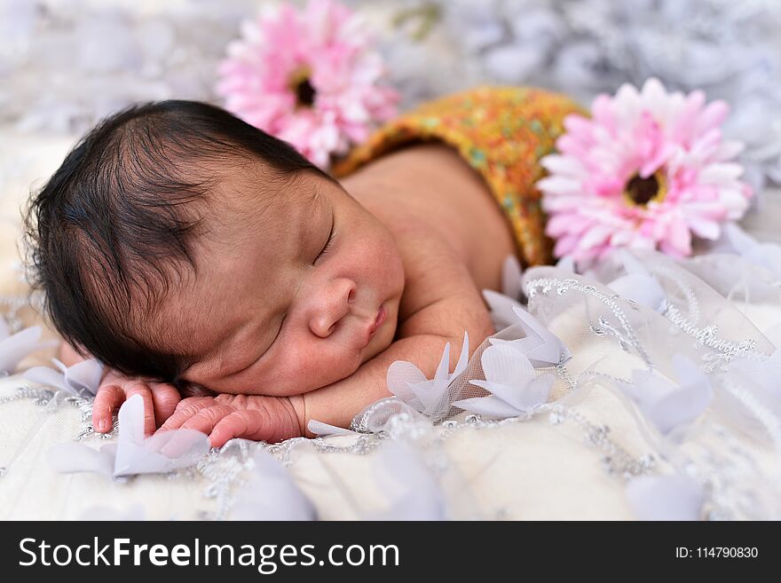 Asian little baby newborn girl sleeping on a lace with flower pattern