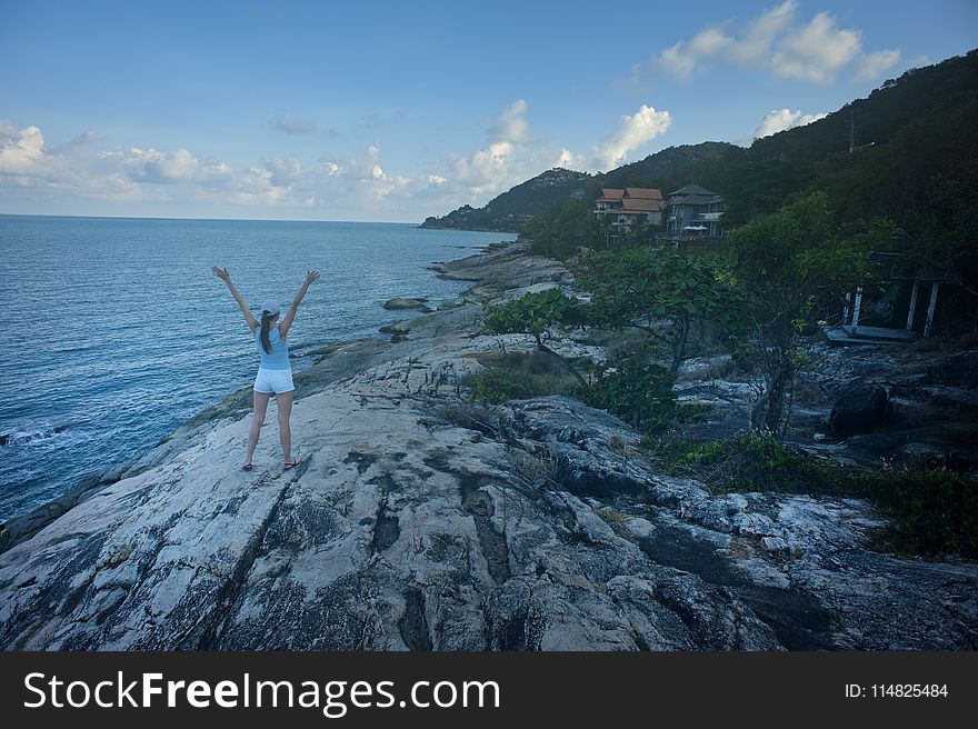 Woman Wearing Blue Tank Top Standing Beside Body Of Water