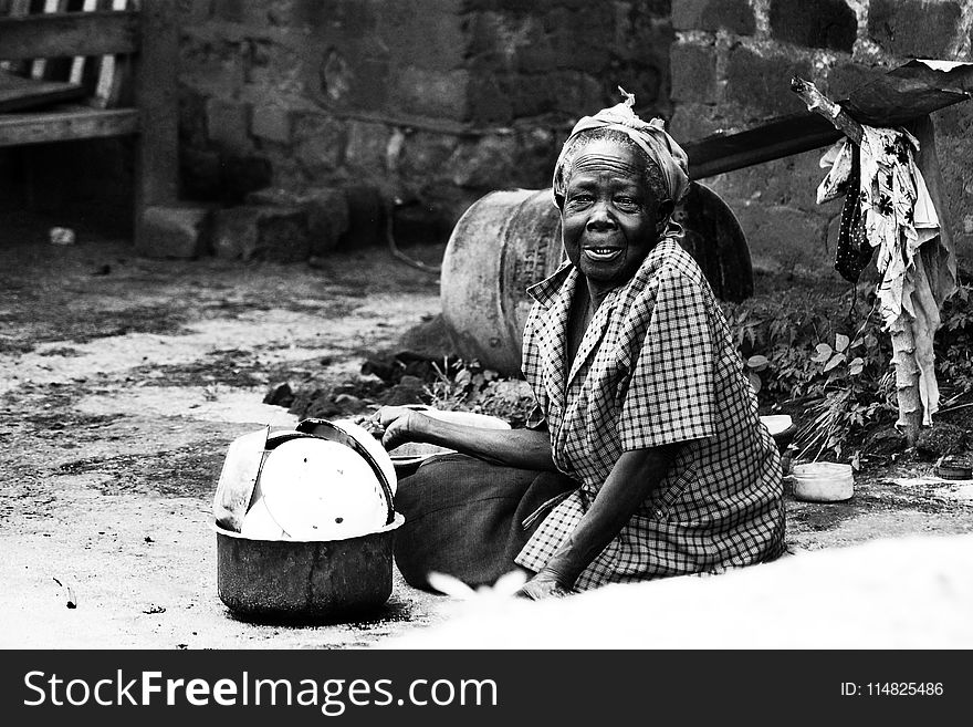 Woman Sitting on Soil Beside Cooking Pot