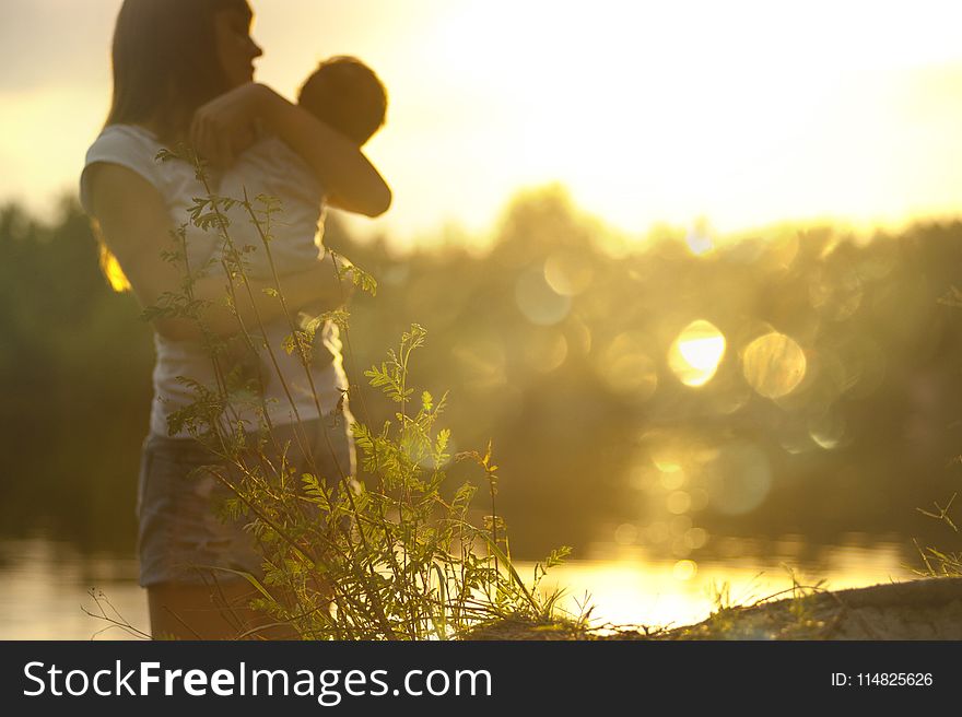 Selective Focus Photography of Woman Carrying Baby