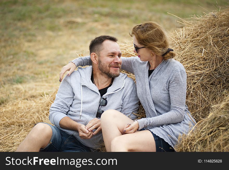 Man and Woman Sitting on Hay