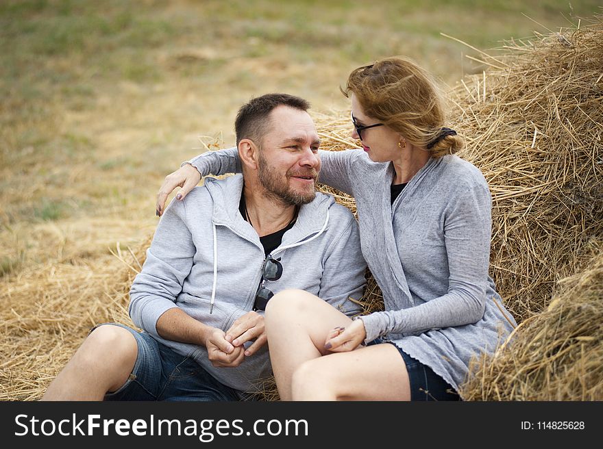 Man And Woman Sitting On Hay