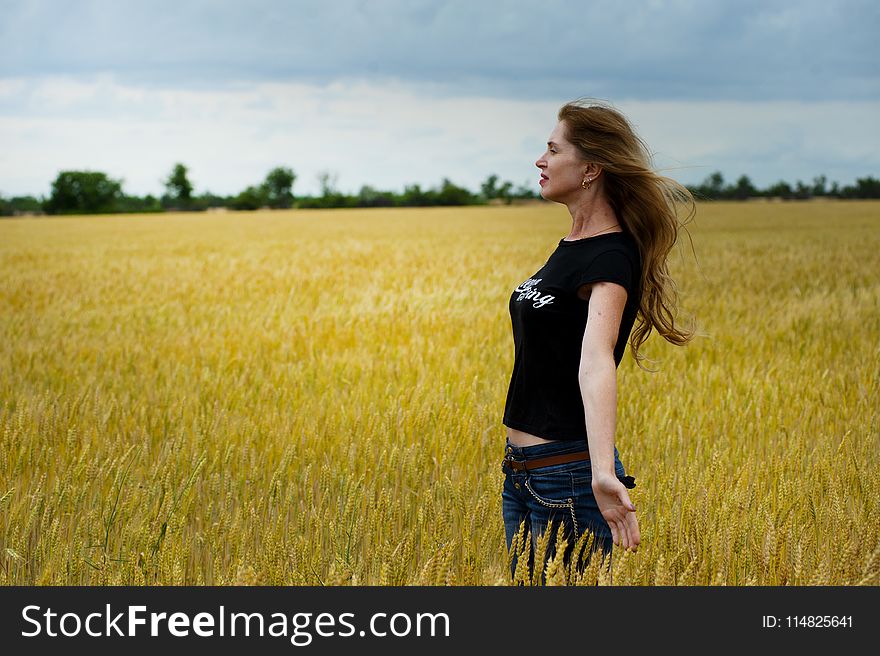 Woman Wearing Black Shirt Surrounded by Grass