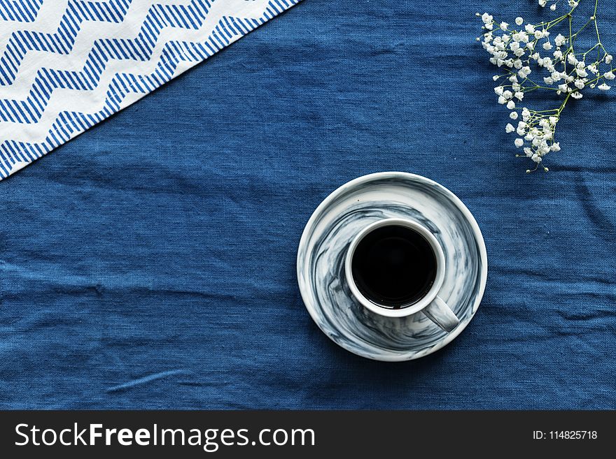 Closeup Photo of Gray and Black Teacup Filled by Coffee With Saucer