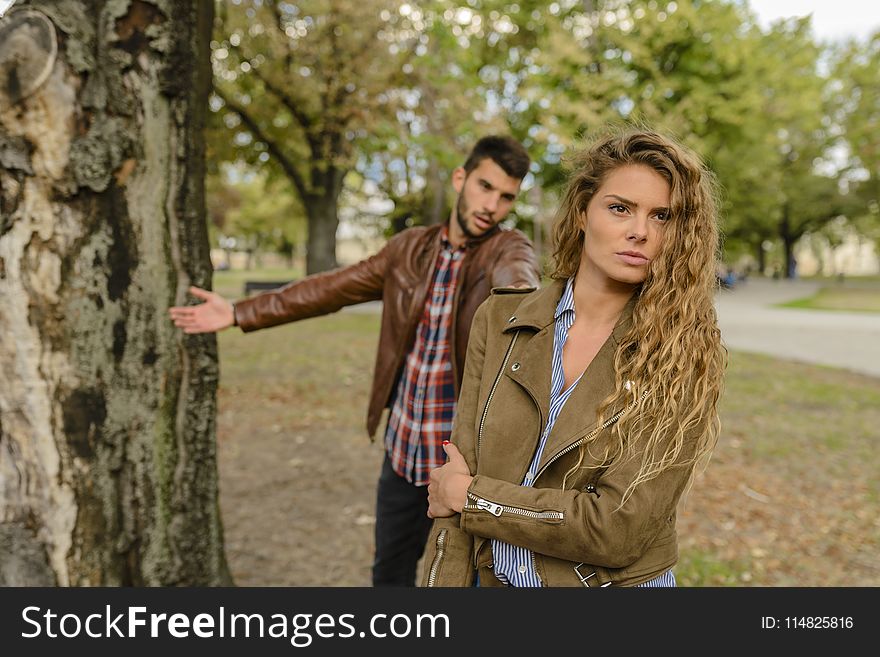 Woman And Man Wearing Brown Jackets Standing Near Tree