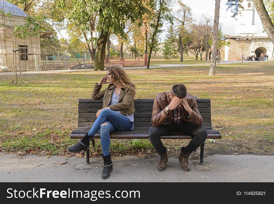 Woman And Man Sitting on Brown Wooden Bench