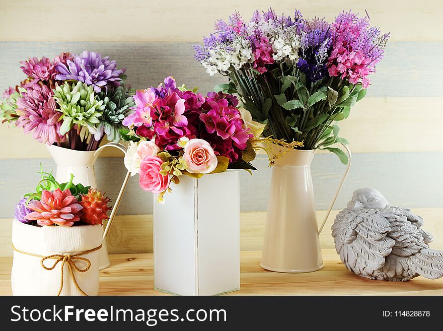 Colorful decoration artificial flower bouquet and bird statue on wooden Shelves