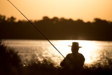 Fisherman With A Fishing Rod At Sunset Stock Image