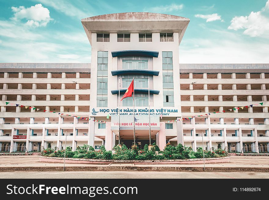 White Concrete Building With Red Flag Outside