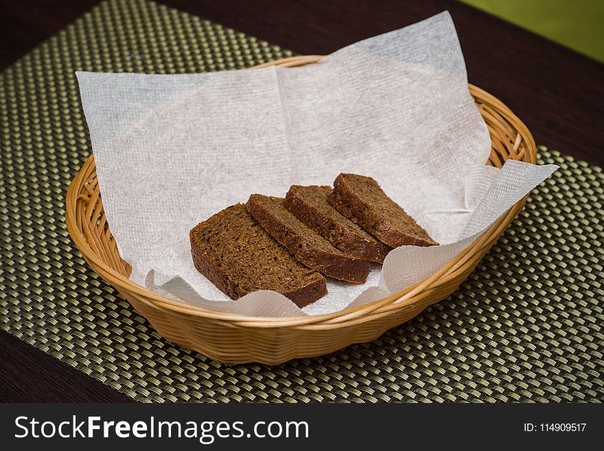 Four slices of black bread on a napkin in a basket