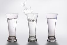 Three Glasses And A Splash Of Water Stock Photos