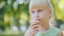 Thoughtful Girl 6 Years Old Is Eating Ice Cream In The Park. Holiday In Summer And Vacations Stock Image