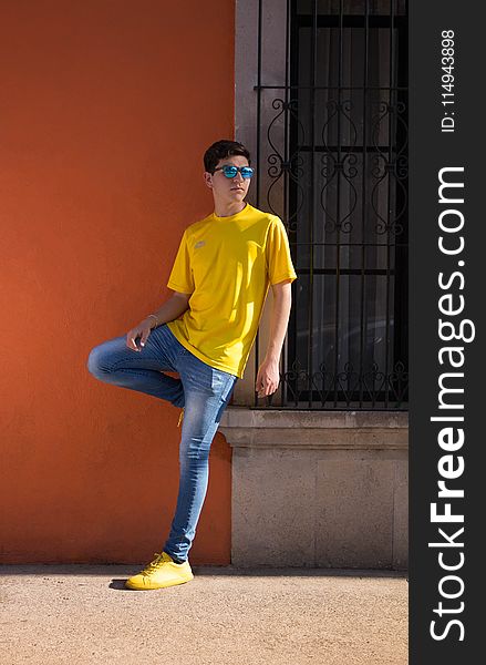 Man Wearing Yellow Crew-neck T-shirt And Blue Denim Jeans