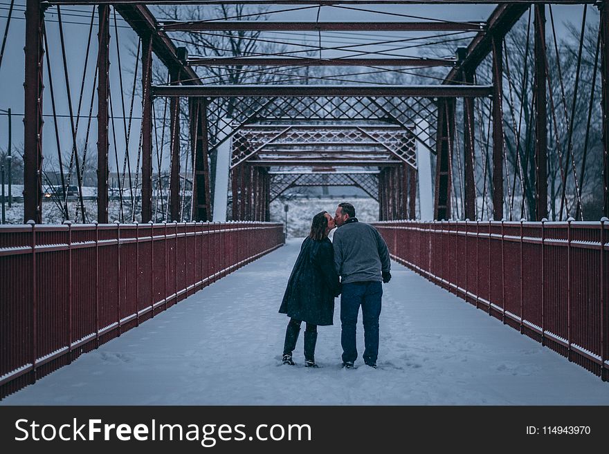 Couple Kissing on Bridge Covered With Snow