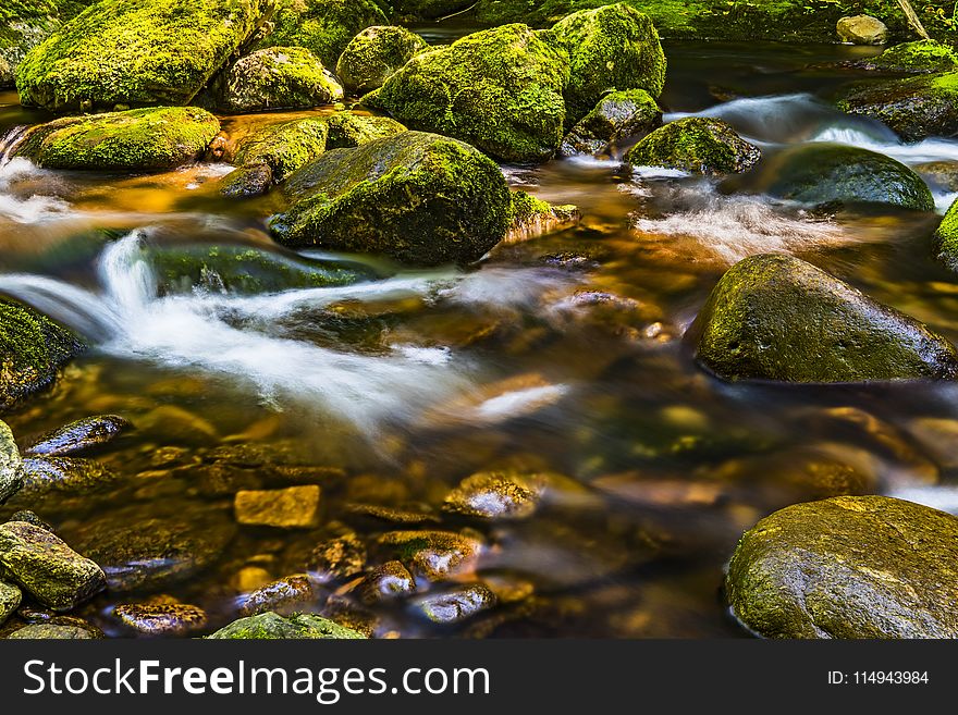 Timelapse Photography of River Flowing Through Moss-covered Rocks