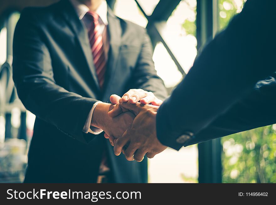 Two confident businessman shaking hands for demonstrating their