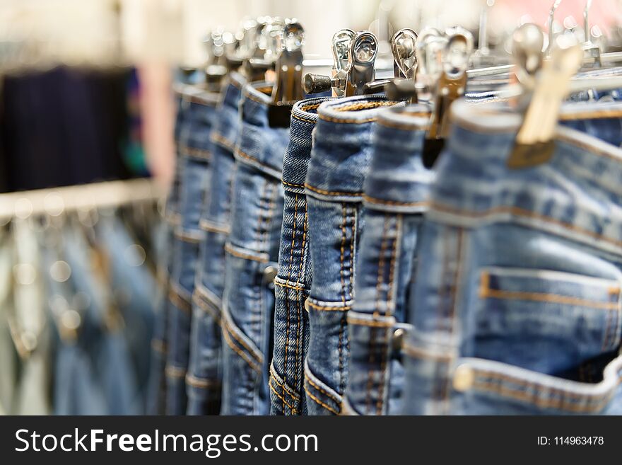 Set of blue jeans hanging on hangers in shop