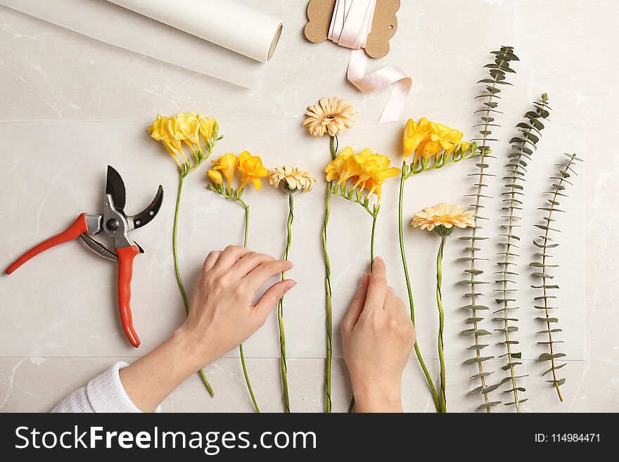 Female florist making beautiful bouquet at table