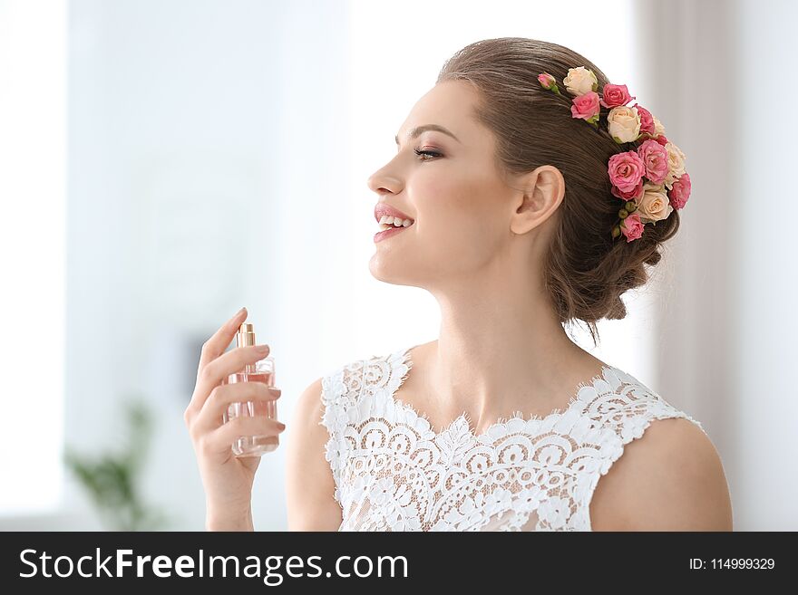 Beautiful young bride with bottle of perfume