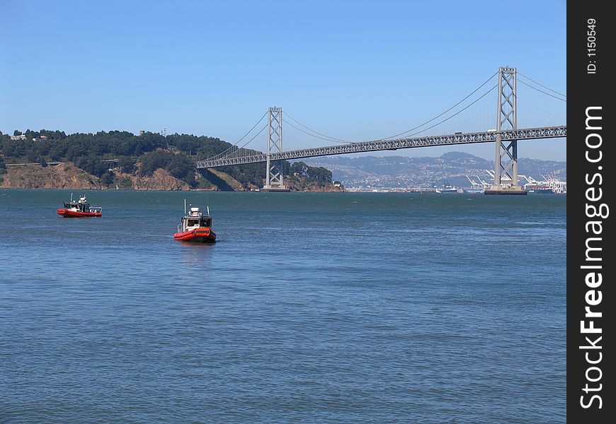 Two Coast Guard cutter ships in San Francisco Bay, with the Bay Bridge in the distance. Two Coast Guard cutter ships in San Francisco Bay, with the Bay Bridge in the distance.