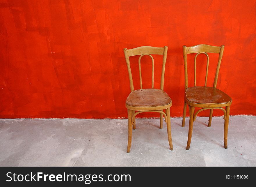 Two chairs befre red wall