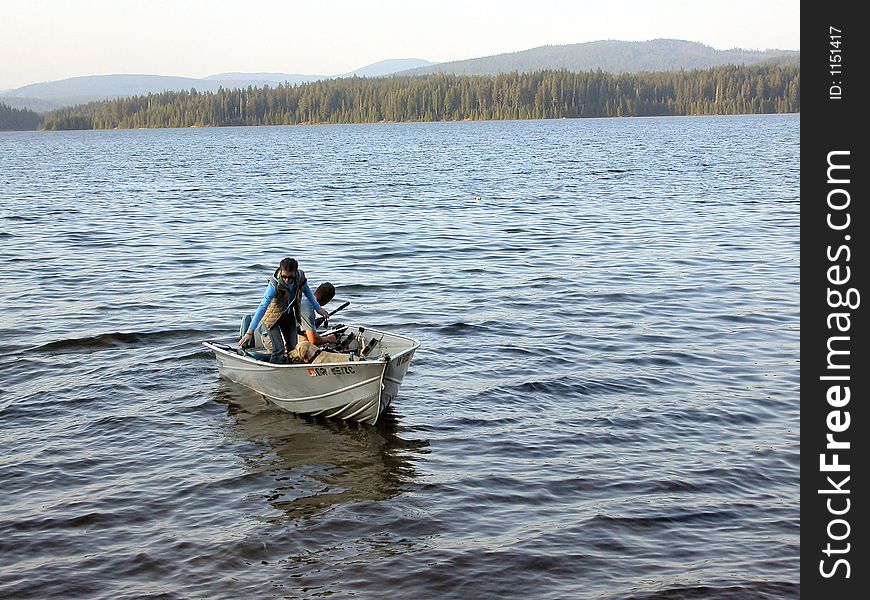 A couple comes back to shore at sunset time after an afternoon of fishing Timothy Lake