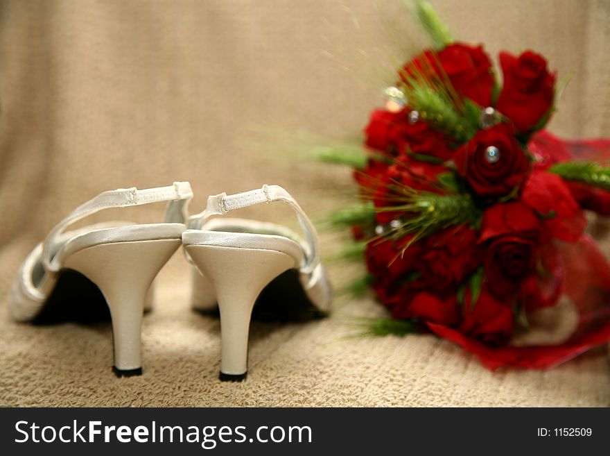 Pare of white shoes and rose bouquet